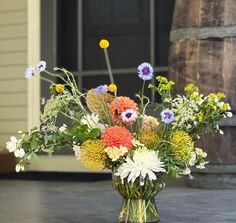 a vase filled with lots of different colored flowers