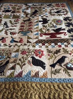 a quilt with birds and flowers on it