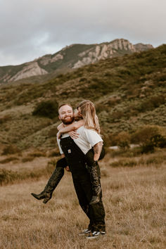 a man holding a woman in the middle of a field