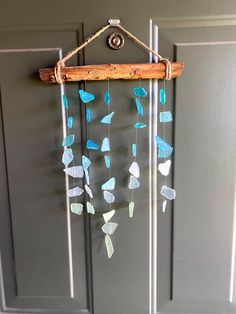 a wind chime hanging from the side of a door with sea glass on it