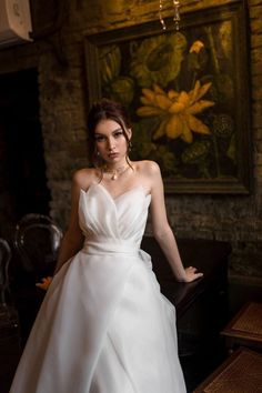 a woman in a white dress posing for a photo