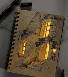 a notebook with a drawing of a house on it