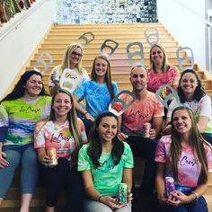 a group of people that are sitting on the steps together with some drinks in front of them