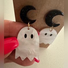 a pair of ghost earrings is being held up