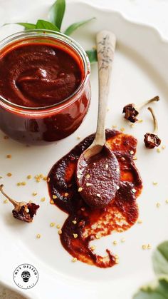 a white plate topped with food next to a jar of sauce