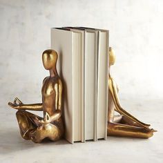 a gold statue sitting next to an open book