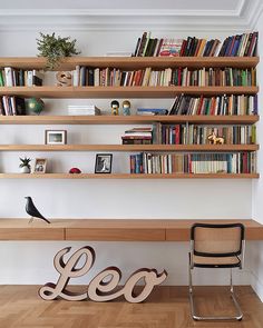 a chair sitting in front of a bookshelf filled with lots of books next to a wooden bench