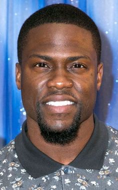 a close up of a person wearing a flowered shirt and smiling at the camera