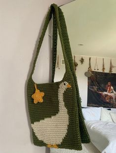 a crocheted bag hanging on the wall next to a bed