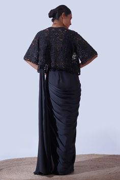 Black flared sleeves cut work cape with all over helix garden embroidery using tonal crystals, beads embroidery and dangling bead tassels on the hem. Paired with a padded draped V neck blouse and a pre-draped saree with tonal crystal gardenia embellishments on the centre saree skirt panel. - Aza Fashions Sarees Black, Saree Skirt, Bead Tassels, Draped Saree, Garden Embroidery, Crystals Beads, Beads Embroidery, Drape Saree, Black Flare