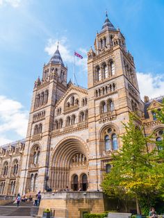 the building is very large and has two towers on each side with flags flying from them