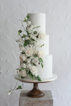 a three tiered cake with white flowers on top