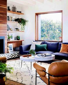 a living room filled with furniture and a fire place in front of a large window