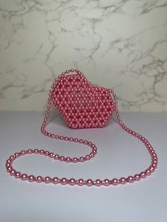 Handmade Heart Shaped beaded bag.  This Beautiful hot pink beaded bag will be a perfect COMPLEMENT to your Valentine's date outfit❤️ The strap is 47 inches long. Don't worry about the bag breaking or the strap, cause I used 40lb  fishing line and it makes the bag pretty sturdy. Plus I make my bags by using a special technique.  The bag is made of acrylic pearl beads with a touch of Preciosa Czech beads . Those small crystal beads make the bag look so stylish.  The bag will fit: airpods, small cardholder, lipstick, travel size perfume, keys, a small mirror and gum. The size is: H(4")*W(5.5")*D(2.5") Care instructions will be included in the order :) Pink Beaded Bag, Heart Beaded Bag, Valentines Date Outfit, Pearl Beaded Bag, Valentines Day Bags, Seed Bead Jewelry Patterns, Bead Bag, Travel Size Perfume, Small Mirror