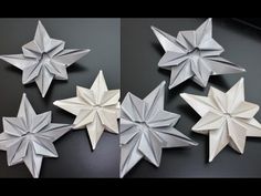 four white origami stars sitting on top of a black table next to each other