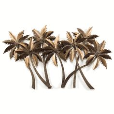 three metal palm trees are shown against a white background, one is gold and the other has brown leaves