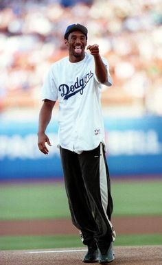 a man standing on top of a baseball field holding his fist up in the air