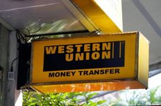 a sign hanging from the side of a building that says western union money transferer