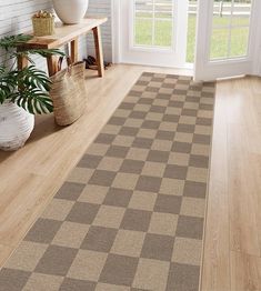 a brown and white checkered rug in a living room next to a potted plant