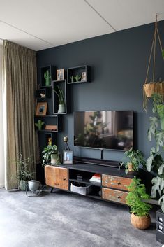 a flat screen tv sitting on top of a wooden entertainment center in a living room