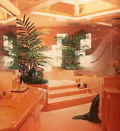 a bathroom with pink marble counter tops and plants in the bathtub, along with two sinks