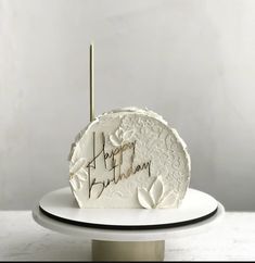 a white cake with writing on it sitting on a plate