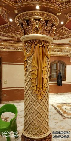 an elaborately decorated pillar in the middle of a room with chairs and tables around it