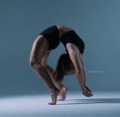 a woman is doing a handstand on the floor