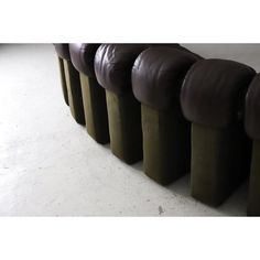 a row of brown leather seats sitting on top of a white floor next to each other