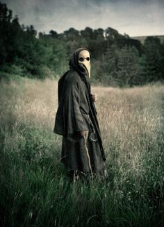 a person wearing a mask standing in a field