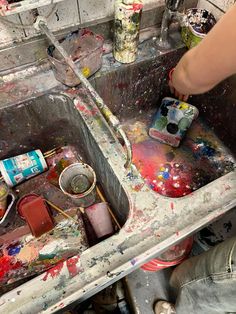 a dirty sink filled with lots of paint