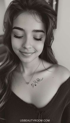 black and white photograph of a woman with her eyes closed, smiling at the camera