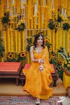 a woman sitting on a bench in front of flowers