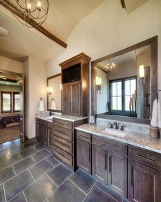 a large bathroom with double sinks and mirrors on the wall, along with tile flooring