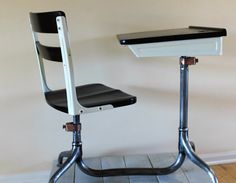 a desk and chair sitting on top of a hard wood floor next to a wall