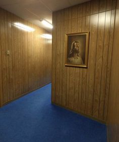 an empty room with wooden walls and blue carpet