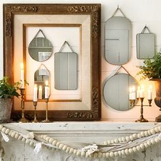 a mantle with candles and mirrors on it