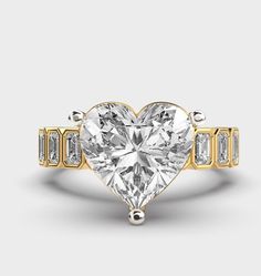 a heart - shaped diamond ring with three baguets on the band, set in 18k yellow gold