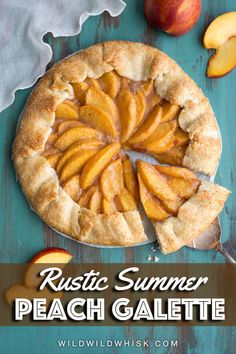 an apple pie with slices cut out on a blue wooden table next to sliced peaches