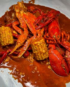 cooked lobsters and corn on the cob with gravy