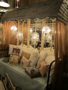 an image of a bed with lots of pillows on it's headboard and some lights hanging from the ceiling