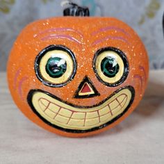 an orange pumpkin with a creepy face painted on it