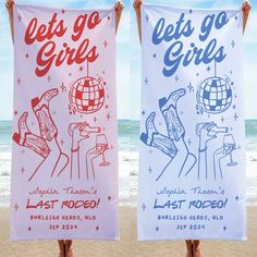 two women holding up towels with the words let's go girls on them at the beach