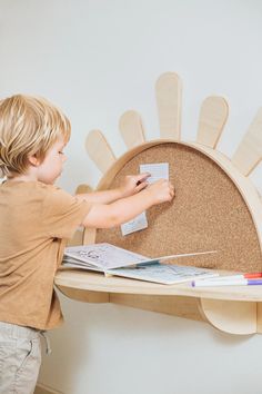 a little boy that is standing in front of a desk