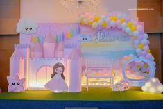 a princess themed birthday party with balloons and decorations on the stage, including a castle