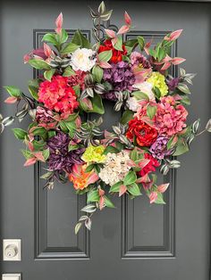 a wreath with flowers is hanging on the front door to decorate it for someone's special occasion