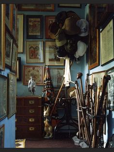 a room filled with lots of different types of hats and umbrellas hanging on the wall