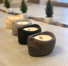 three candles sitting on top of a counter next to each other in different shapes and sizes