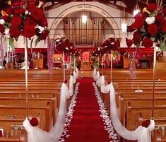 the aisle is decorated with red and white flowers