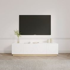 a flat screen tv mounted to the side of a white wall in a living room